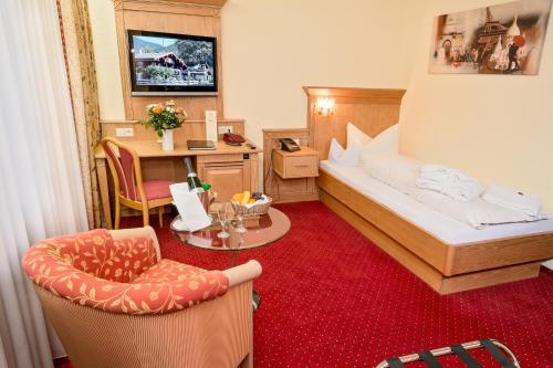 a hotel room with a bed and a chair at Wellness Privathotel Post an der Therme in Badenweiler