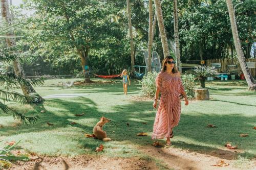 a woman walking in a park with a dog at El Mosquito Boutique Hotel Playa Bonita in Las Terrenas
