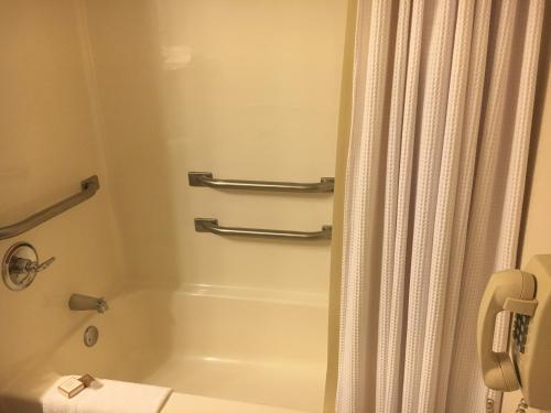 a bathroom with a tub and a shower curtain at Hotel Grand Victorian in Branson