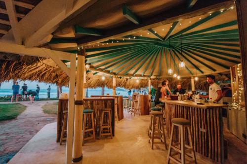 a restaurant with a bar with a view of the ocean at El Mosquito Boutique Hotel Playa Bonita in Las Terrenas
