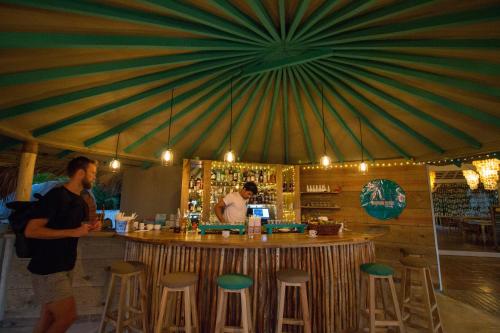 a man standing at a bar in a restaurant at El Mosquito Boutique Hotel Playa Bonita in Las Terrenas