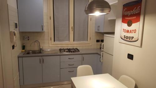 una piccola cucina con armadi bianchi e lavandino di Juli's guest house a Bologna