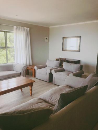 a living room with couches and a coffee table at Periwinkle Selfcatering 8 in Franskraalstrand