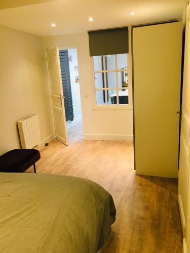 une chambre avec un lit et une grande fenêtre dans l'établissement Appartement Héloïse, le charme du Vieux-Lille, à Lille