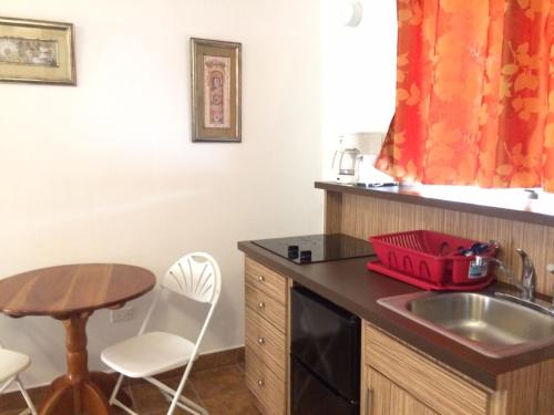 a small kitchen with a sink and a table at Easy Inn Hotel in Belize City