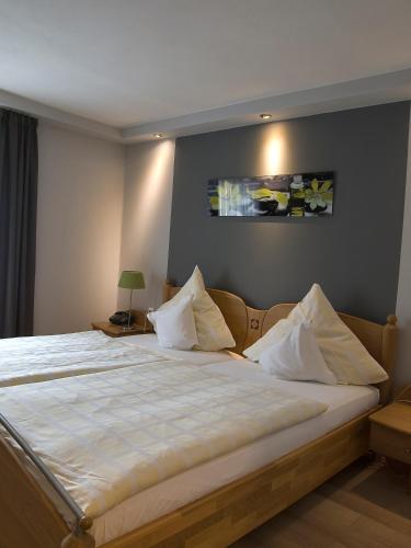 a bedroom with a large bed with white sheets at Hotel Rose in Warburg