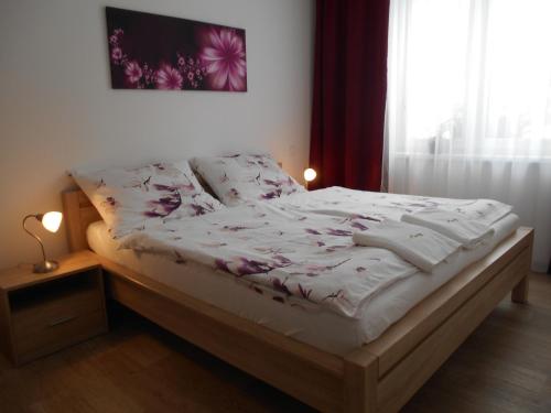 a bedroom with a bed with white sheets and a window at Apartmán u Toma in Frýdlant nad Ostravicí