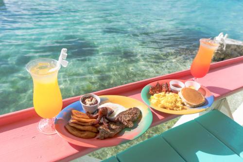 a tray of breakfast food on a table next to the water at Graham's Place in Guanaja
