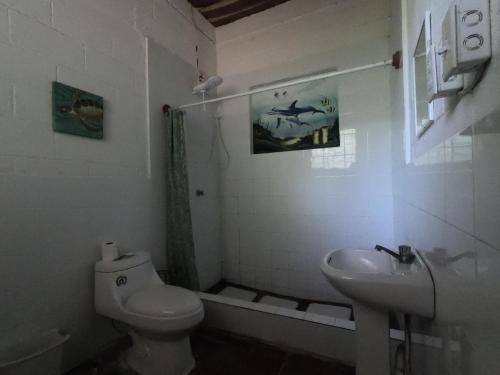 a bathroom with a toilet and a sink at Hammock plantation in El Zonte