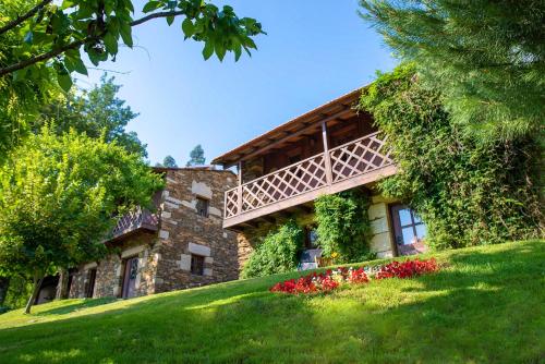 a stone house with flowers in front of it at Quinta da Rabaçosa - Turismo Rural in Castro Daire