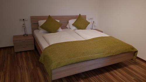a bedroom with a bed with a green blanket on it at Haus Sabrina in Kaltenbach