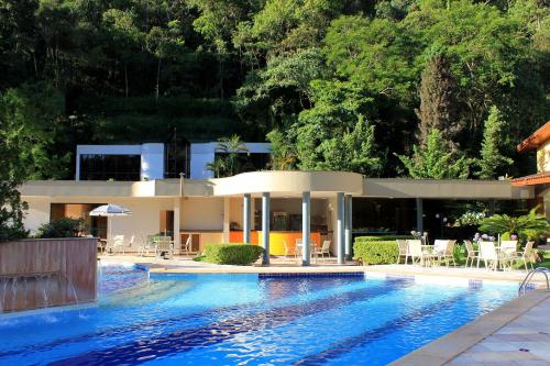 uma piscina em frente a uma casa em Hotel Recanto das Hortênsias em Passa Quatro