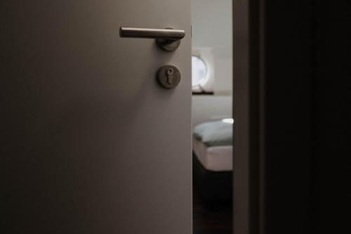 汉堡Schiffshotel "Schlafen im Hafen"的一张床间的门,带把手