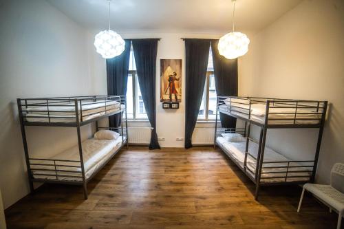 2 łóżka piętrowe w pokoju z 2 oknami w obiekcie Sleep&Go w Pradze