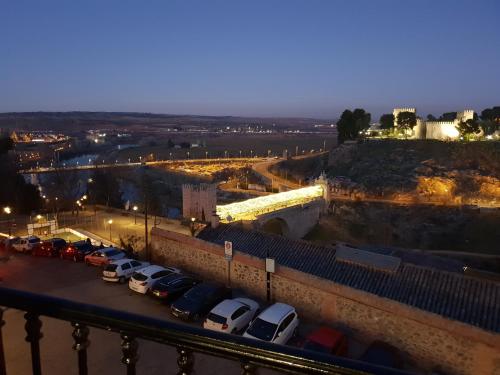 a parking lot with cars parked next to a bridge at Mirador de Cervantes in Toledo