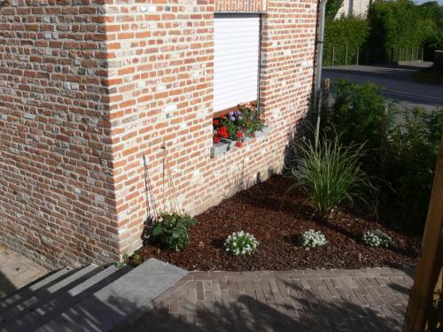 a garden in a brick building with flowers in a window at Casa della Nonna in Zwalm