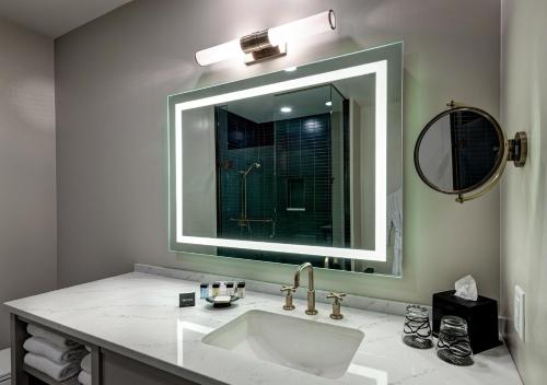 a bathroom with a sink and a large mirror at The Hotel Concord in Concord
