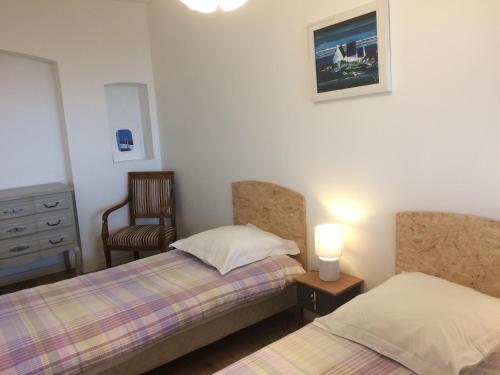 1 Schlafzimmer mit 2 Betten, einem Stuhl und einer Kommode in der Unterkunft Appartement avec terrasse pour 4 personnes in Athis-Mons