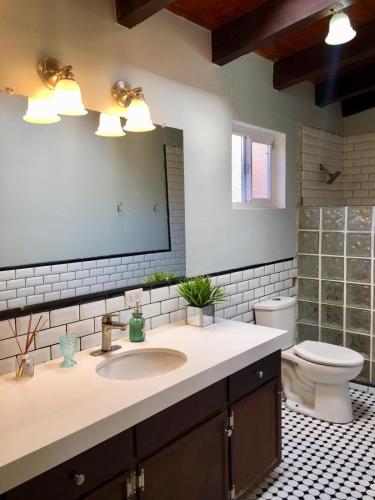 a bathroom with a sink and a toilet and a mirror at Rosarito Beach House-- Spacious, Central, Beach View, & Sleeps 14 in Rosarito