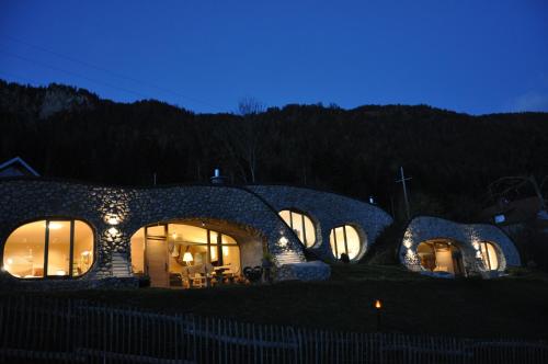 a stone house with lights on it at night at Himmelsbögen und Apartments mit Seeblick und Alleinlage in Weissensee