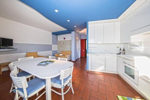Una cocina y un comedor con una mesa y sillas blancas. en Villetta Elise, en Padenghe sul Garda