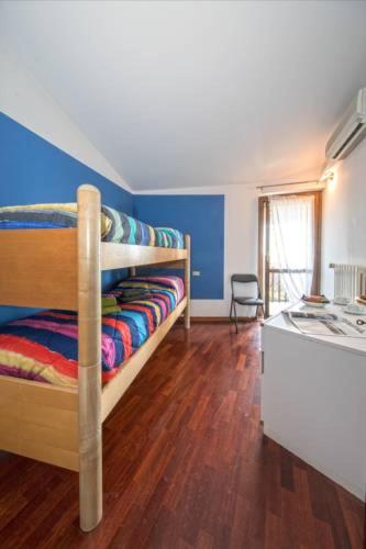 a bedroom with two bunk beds and a kitchen at Villetta Elise in Padenghe sul Garda