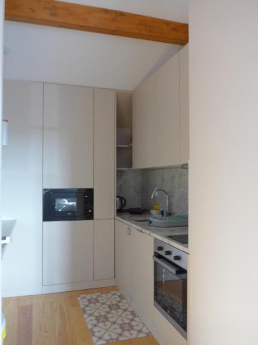a kitchen with white cabinets and a sink at The Porto Way in Porto