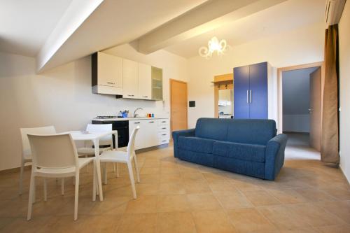 a living room with a blue couch and a table and chairs at Erice Mare in Erice