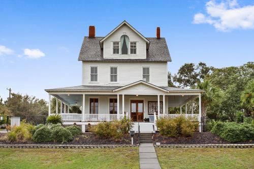 an old white house with a porch at Surf Song Bed & Breakfast in Tybee Island