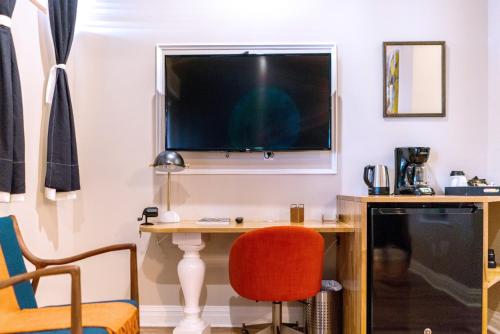 a living room with a tv and a chair at The Box House Hotel in Brooklyn
