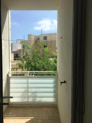an open window with a view of a building at Ocean View, Apartment 1 in Marsaskala