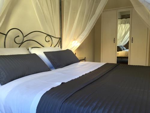 una camera da letto con un grande letto con lenzuola blu e bianche di Suite CALLIOPE - LE MUSE a Pietrasanta