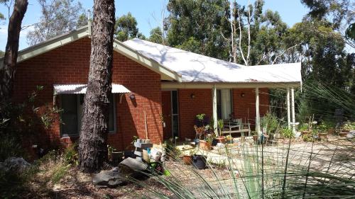 MylorにあるStringybark Hills Retreatの前に木があるレンガ造りの家