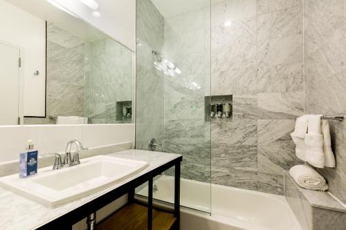 ein Bad mit einem Waschbecken und einer Dusche in der Unterkunft The Box House Hotel in Brooklyn