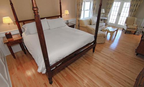 a bedroom with a canopy bed and a living room at Anchor Inn Beach House in Provincetown