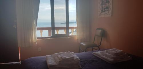 1 dormitorio con cama y vistas al océano en Hostal Utama en Comunidad Yumani