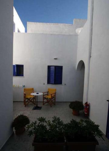 a courtyard with a table and chairs in a building at Villa Happening in Imerovigli