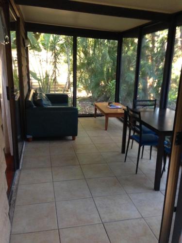 a screened in porch with a table and chairs at Byron Bay Rainforest Resort in Byron Bay