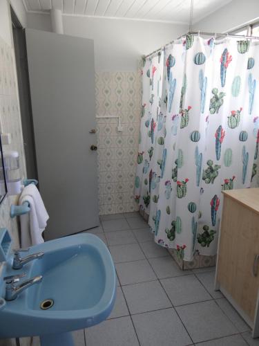 a bathroom with a blue sink and a shower curtain at Departamento acogedor en centro de San Fernando in San Fernando
