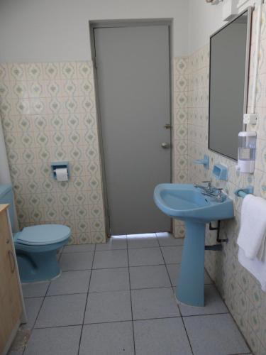La salle de bains est pourvue d'un lavabo bleu et de toilettes. dans l'établissement Departamento acogedor en centro de San Fernando, à San Fernando