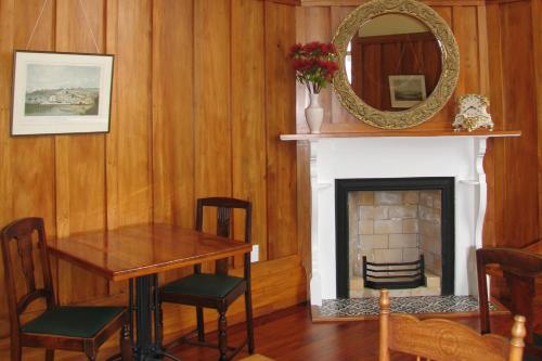 a dining room with a table and a fireplace at Left Bank in Kaikohe