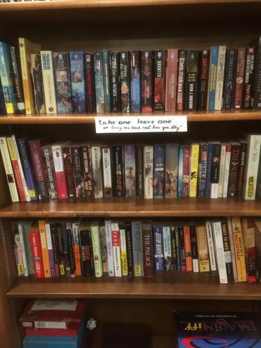 a book shelf filled with lots of books at Cascades Inn in Bloomington