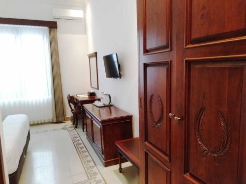 Una televisión o centro de entretenimiento en Daroessalam Syariah Heritage Hotel