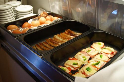 a tray of food with eggs bacon and sausage at Sport Garni Kapplerhof – Ischgl/Kappl in Kappl
