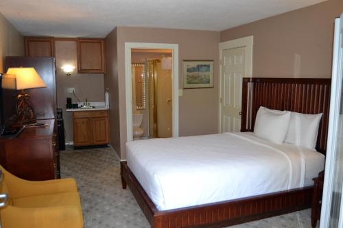 a bedroom with a white bed and a bathroom at Cascades Inn in Bloomington