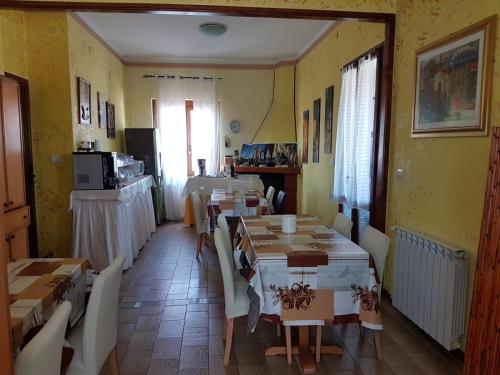 una sala da pranzo con tavoli e sedie in una stanza di B&B Fantar House a Carbonia