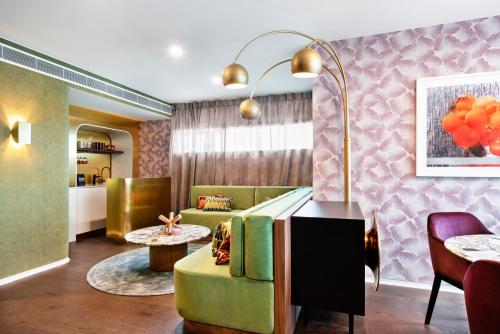 a living room with a green couch and a table at Ovolo The Valley Brisbane in Brisbane