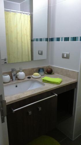 a bathroom with a sink and a mirror at Condominio Arena Maris in Algarrobo