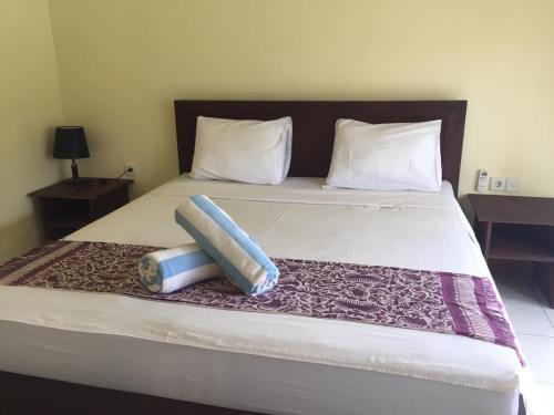 uma cama com duas almofadas em cima em Tanaya Homestay em Amed