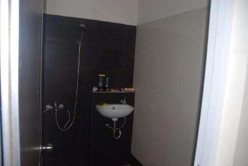 ein Bad mit einer Dusche und einem Waschbecken. in der Unterkunft Resort Faza in Garut
